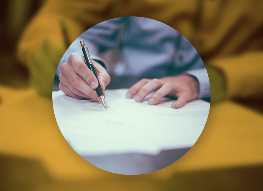 Mužská ruka píšící propisovačkou do knihy symbolizující registraci svěřenského fondu